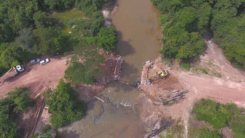Vista aérea de ponte sendo construída sobre o rio