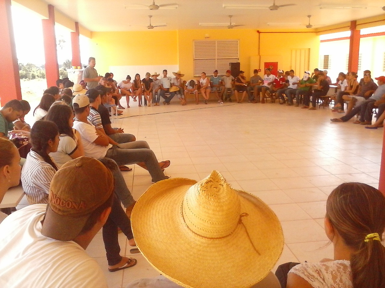 Comunidade reunida em roda no espaço coberto da escola