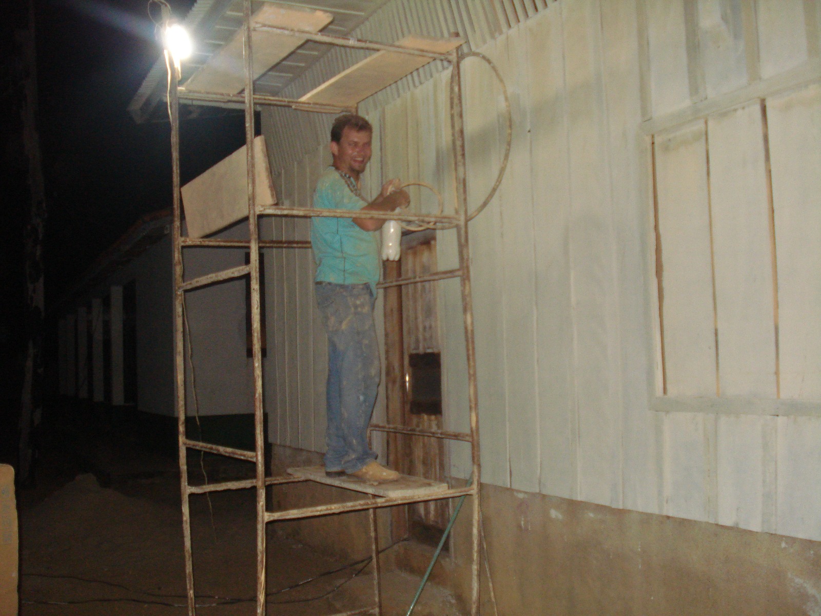 Trabalhador pintando a fachada da escola à noite