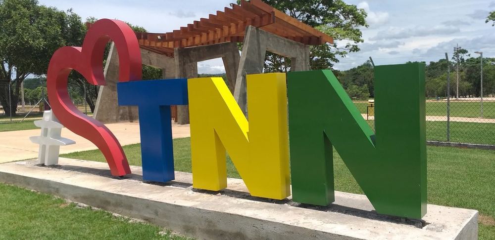Letreiro colorido TNN com coração e pergolado de madeira na entrada do Parque Vale do Esperança